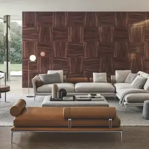 Living room with a light grey sofa, cognac leather bench and a wood parquet-patterned feature wall