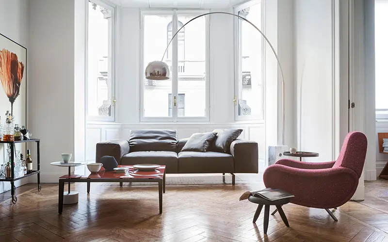Cassina living room with a brown leather sofa, the Arco floor lamp by Castiglioni and a burgundy armchair