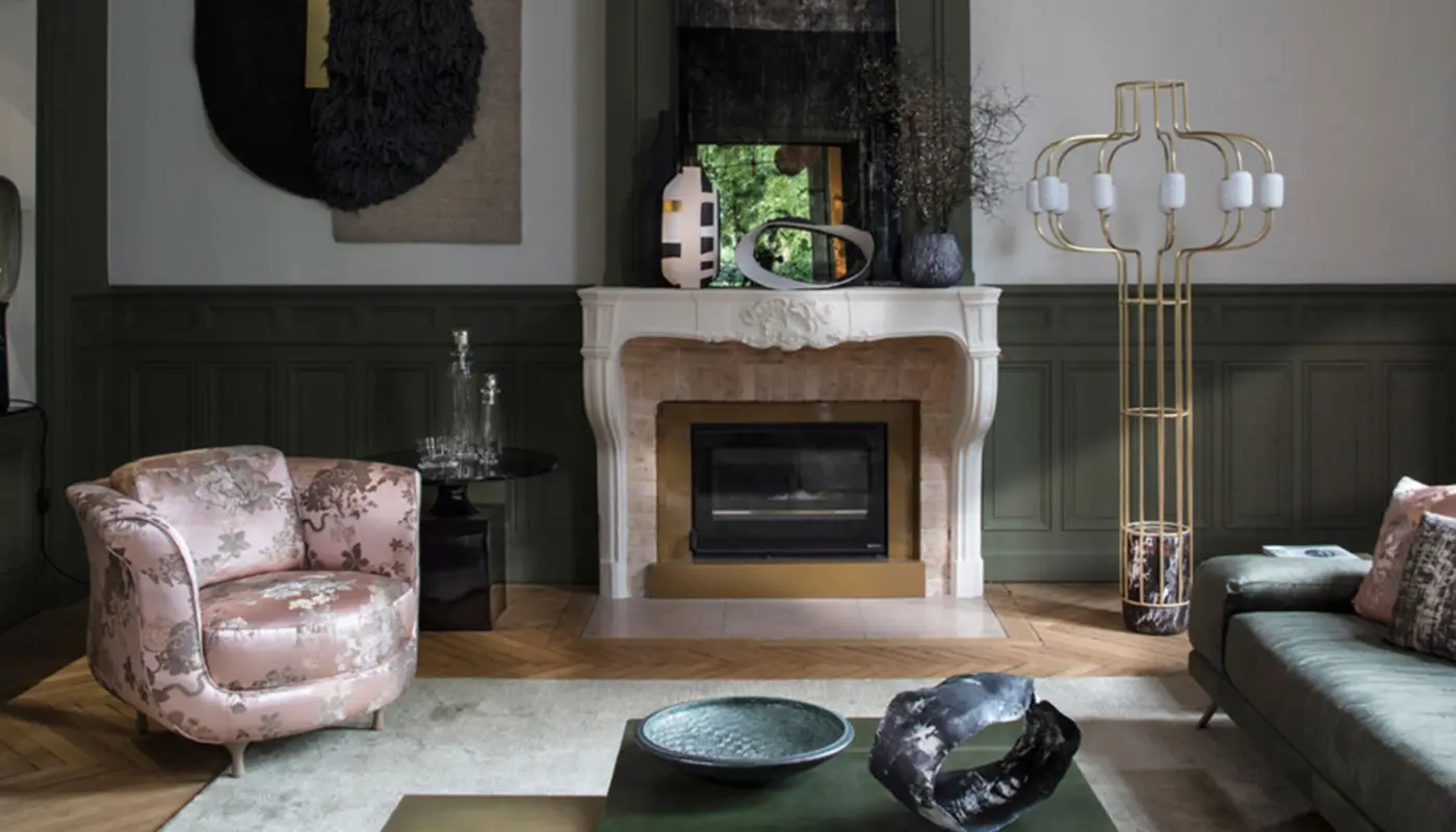 Living room with a Moroso Big Mama floral armchair beside a classic fireplace and gold floor lamp