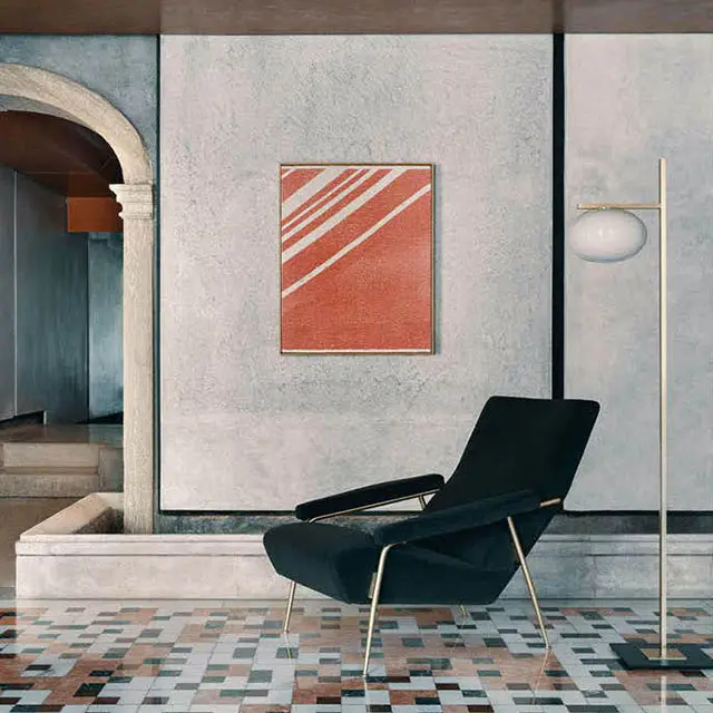 Italian interiors, from the left an arch, a painting, a design armchair and a lamp